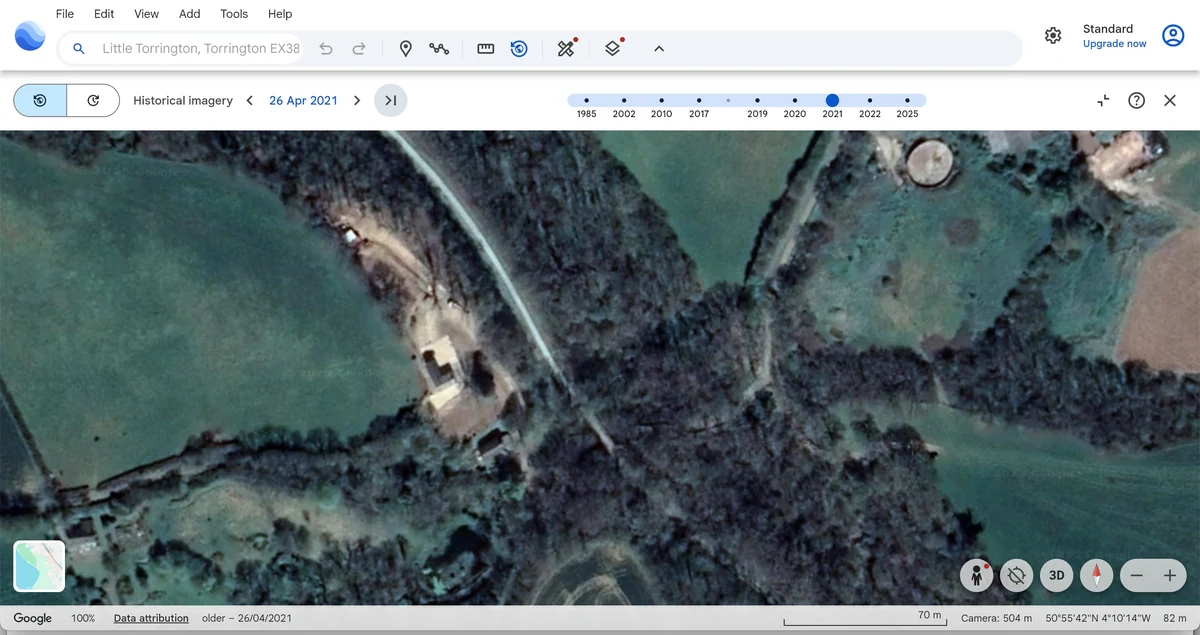 Google Earth historical aerial view dated 26 April 2021 showing open ground and remaining tree cover.